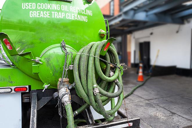 a grease trap being pumped by a sanitation technician in Alpine